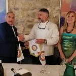 l Delegato consegna il guidoncino allo chef, Roberto Di Sante, insieme all simposiarca Dina Bruni